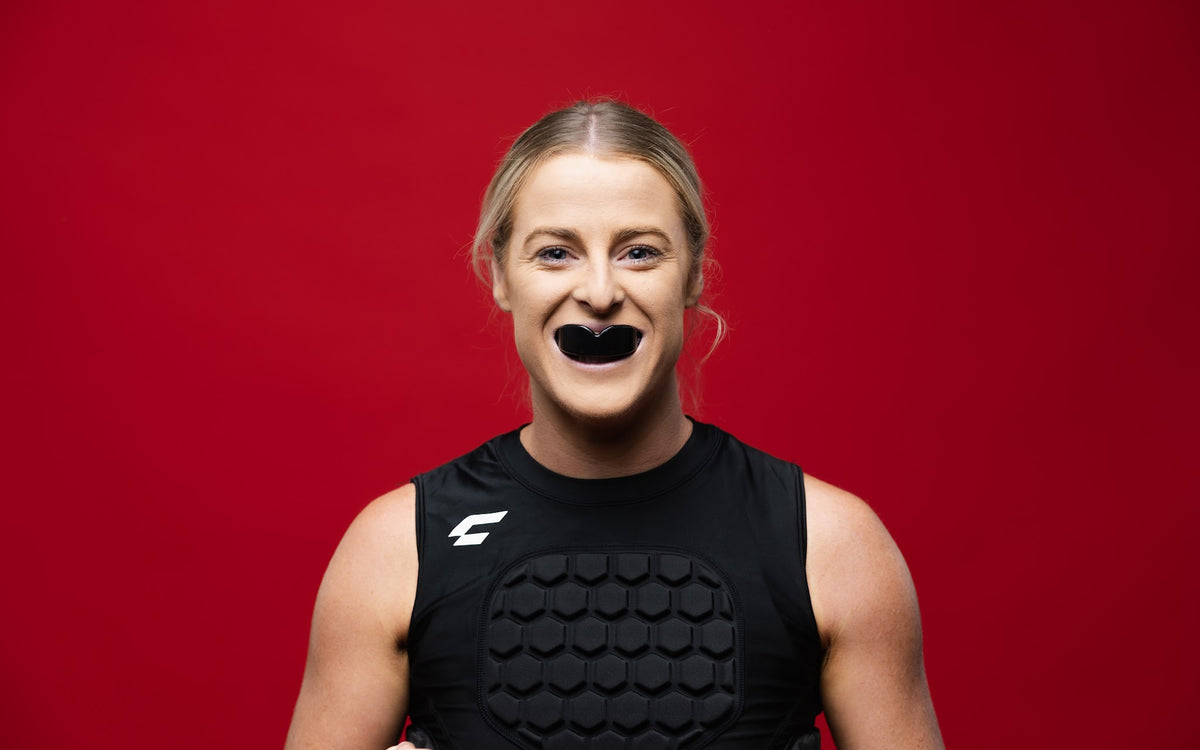 Female athlete wearing the CHAMP C1 Guard-Vest with CHAMP mouthguard