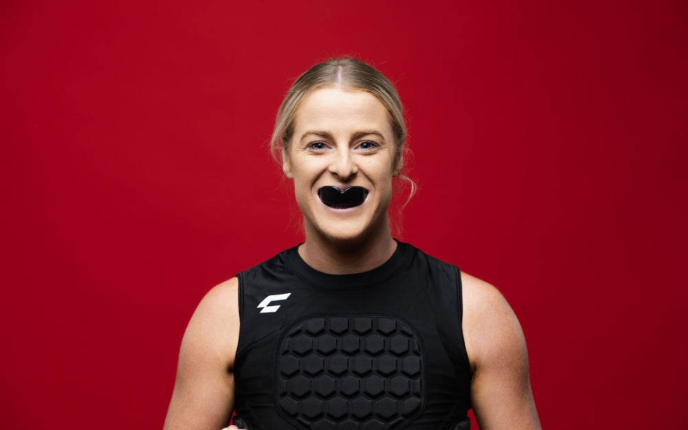 Female athlete wearing the CHAMP C1 Guard-Vest with CHAMP mouthguard